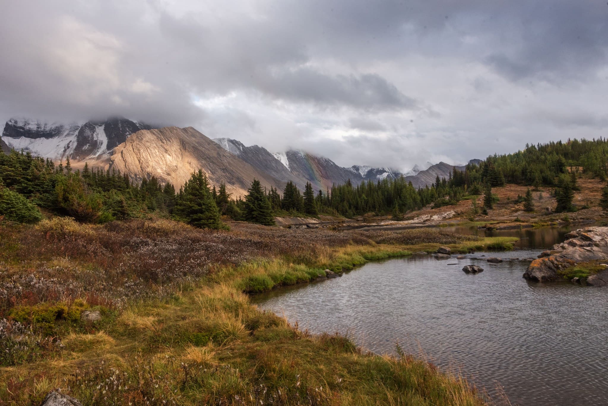 A rainbow hits Tilted Mountain at golden hour